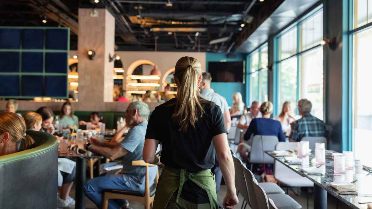 Server walking through a busy restaurant — implementing QR-based bill splitting
