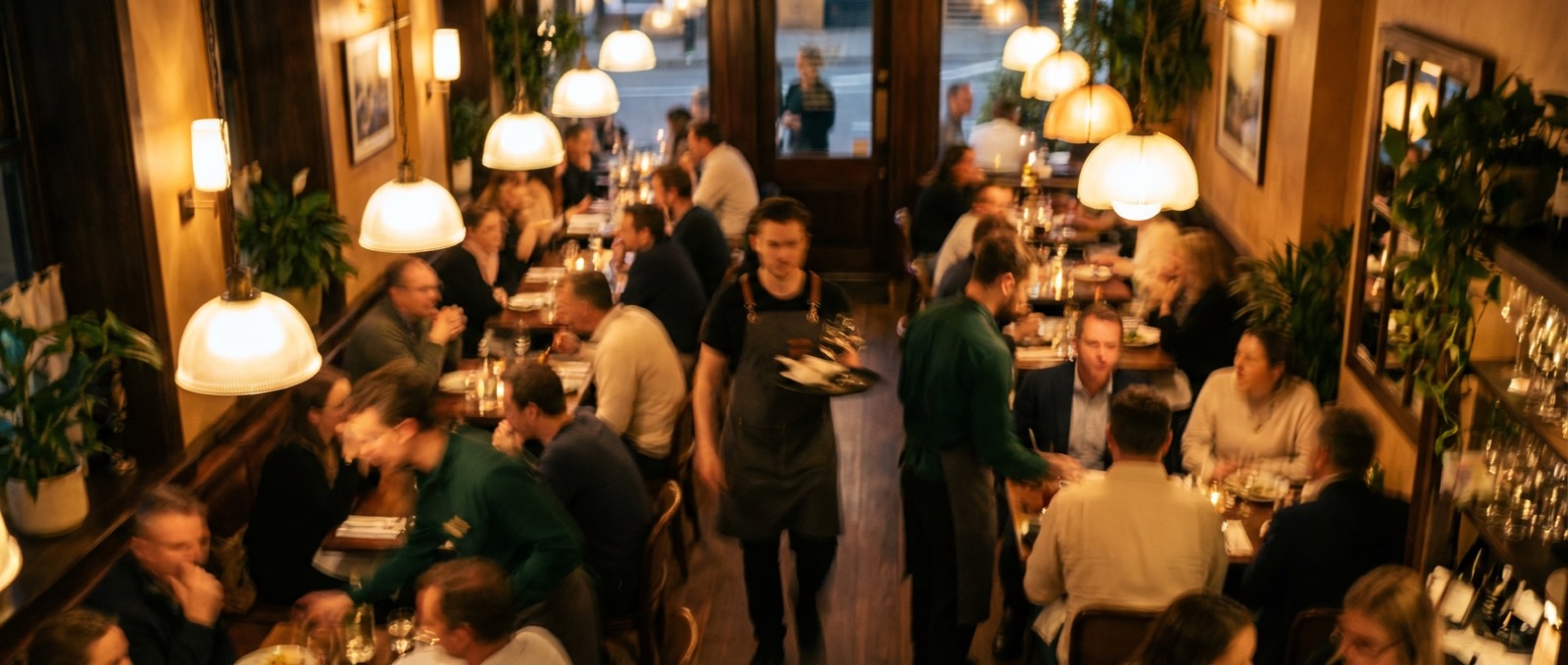 Overhead view of a busy full-service restaurant at dinner service